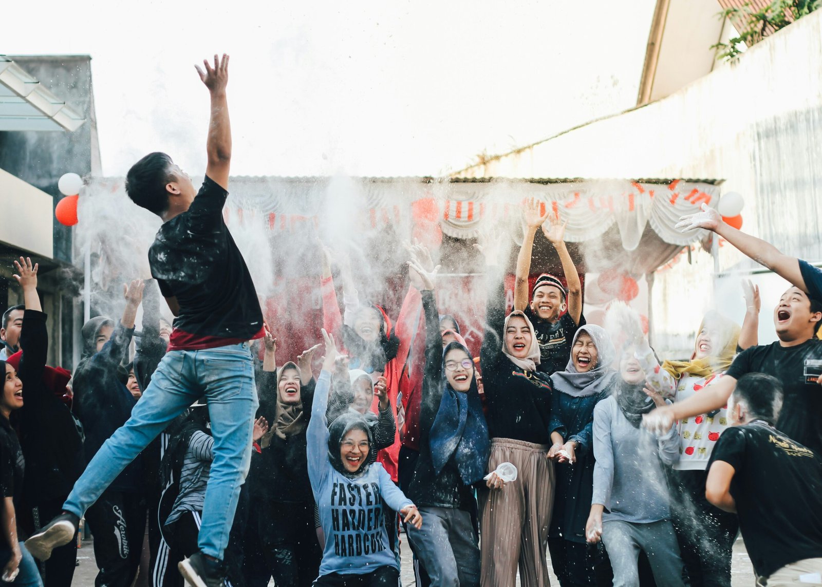 Joyful group celebration with powder in the air, capturing energetic expressions and laughter.