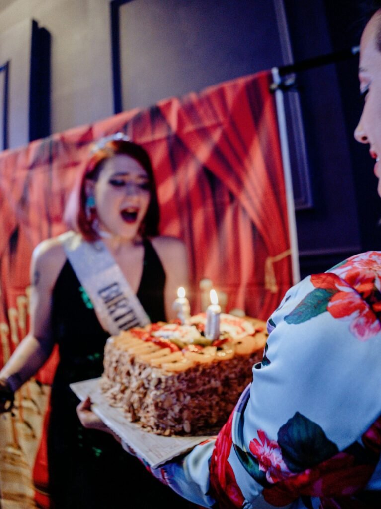 Event Shooting — From $250 Excited woman celebrating with a lit birthday cake, highlighting event photography.