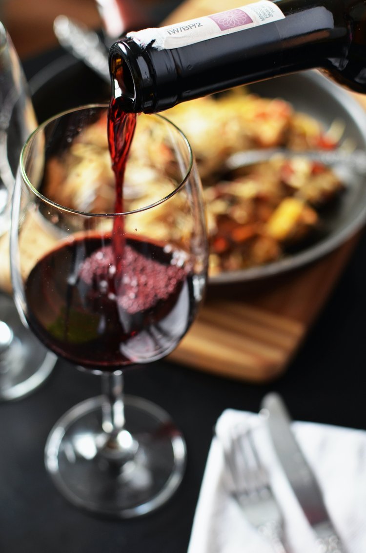 Food Photography — From $200 Pouring red wine into a glass alongside a gourmet dish, showcasing food photography.